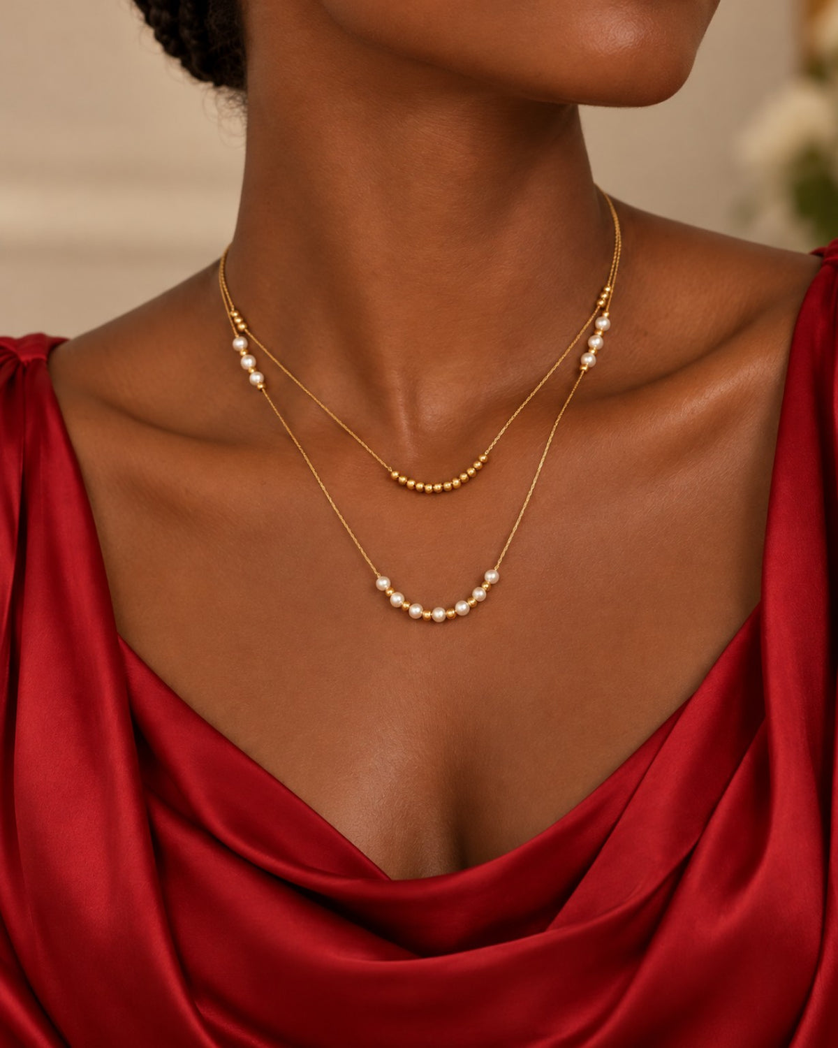 Collier Accord double rang porté avec un haut rouge