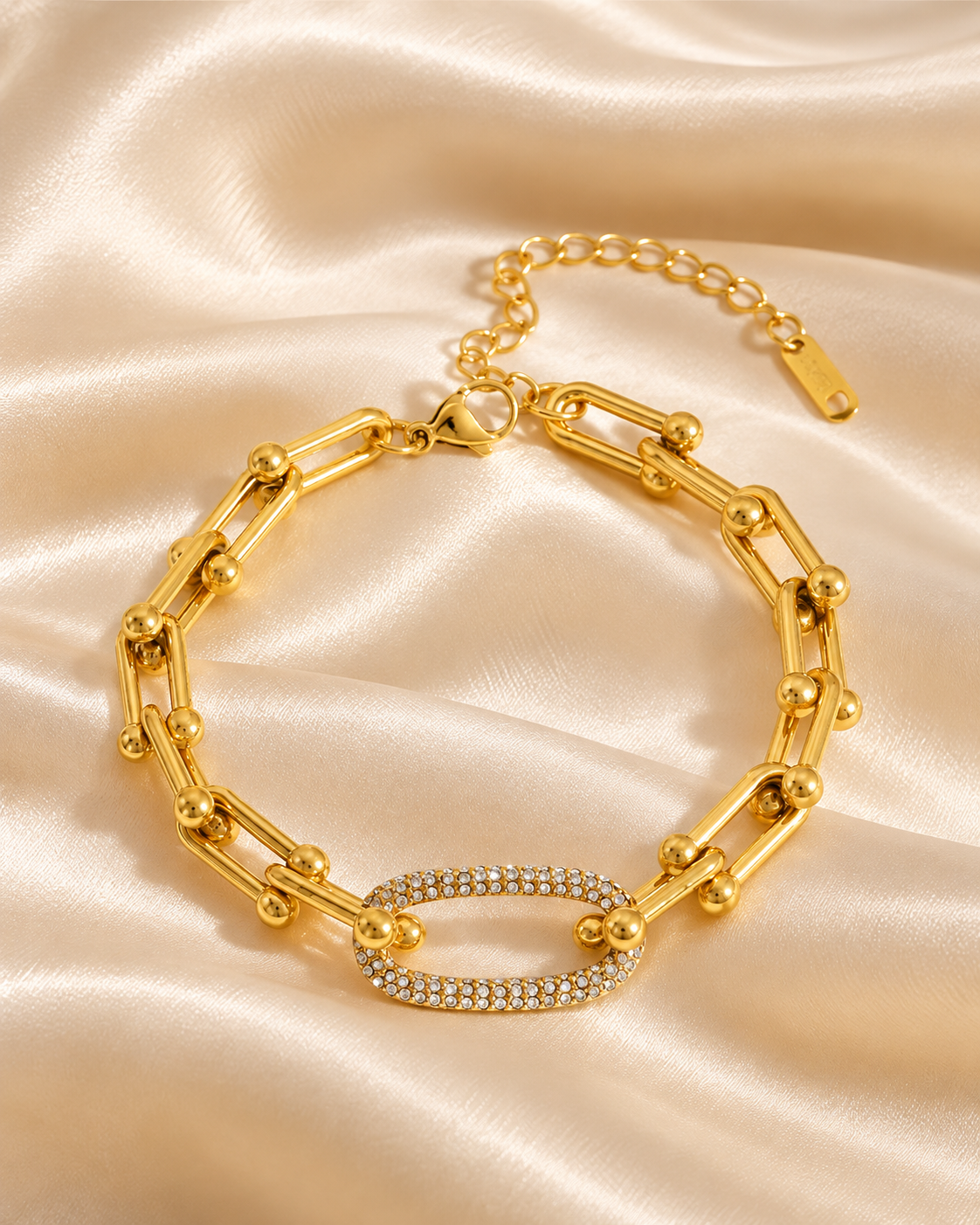 Bracelet doré à maillons et anneau ovale serti de zircons